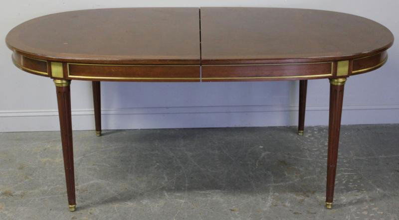 Vintage French Style Brass Mounted Oval Mahogany: Cross Banded Dining Table. With two leafs and drop down center leg. From a Glendale, NY location. Dimensions: 44" wide x 78.5" deep x 30.5" high.