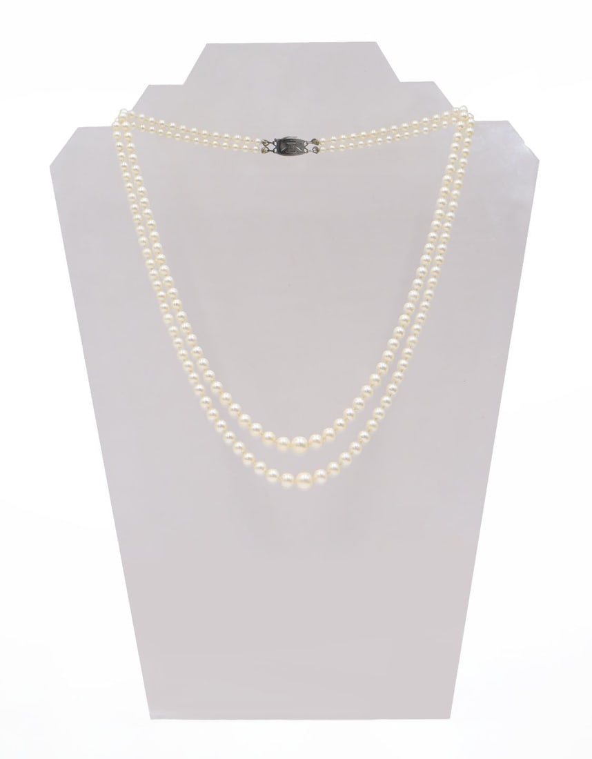 JEWELRY. Mikimoto Double Strand Pearl Necklace.: Mikimoto double strand necklace comprised of individually knotted pearls and a sterling clasp accented by a single pearl. Clasp is stamped verso, "M" within a shaped frame representing Mikim