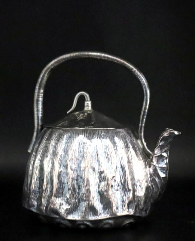 SILVER. Japanese Silver Lotus Pod Teapot.: This signed Japanese silver teapot is crafted in the form of a lotus pod, symbolizing purity and renewal in Japanese culture. The base skillfully emulates the textured surface of a lotus seedpod, addi