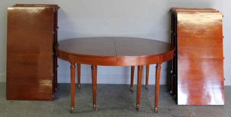 Large Vintage Oval Neoclassical Style Dining Table: with 8 Leaves. Includes original double center legs. From a 5th Avenue and 63rd Street NYC estate. Dimensions: 60" wide x 48" deep x 30" high; Leaf width is 24" each. Condition: Old refinish; bumps an