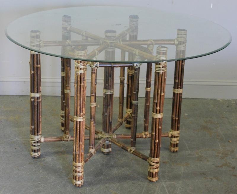 Rattan Center Table with Glass Top.: Possibly McQuire. From a Newburgh, NY estate. Dimensions: 48.5" diameter top x 28.5" high.