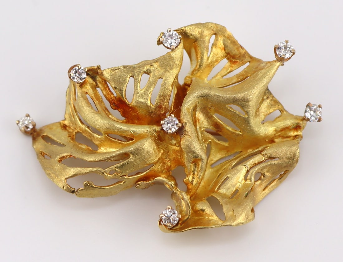 JEWELRY. Ed Wiener 18kt Gold and Diamond Brooch.: Signed Ed Wiener 18kt yellow gold modernist brooch accented by a total of (7) prong-set round brilliant cut diamonds. With a 14kt gold brooch backing. Stamped verso, "EW 18K".Total approx. w