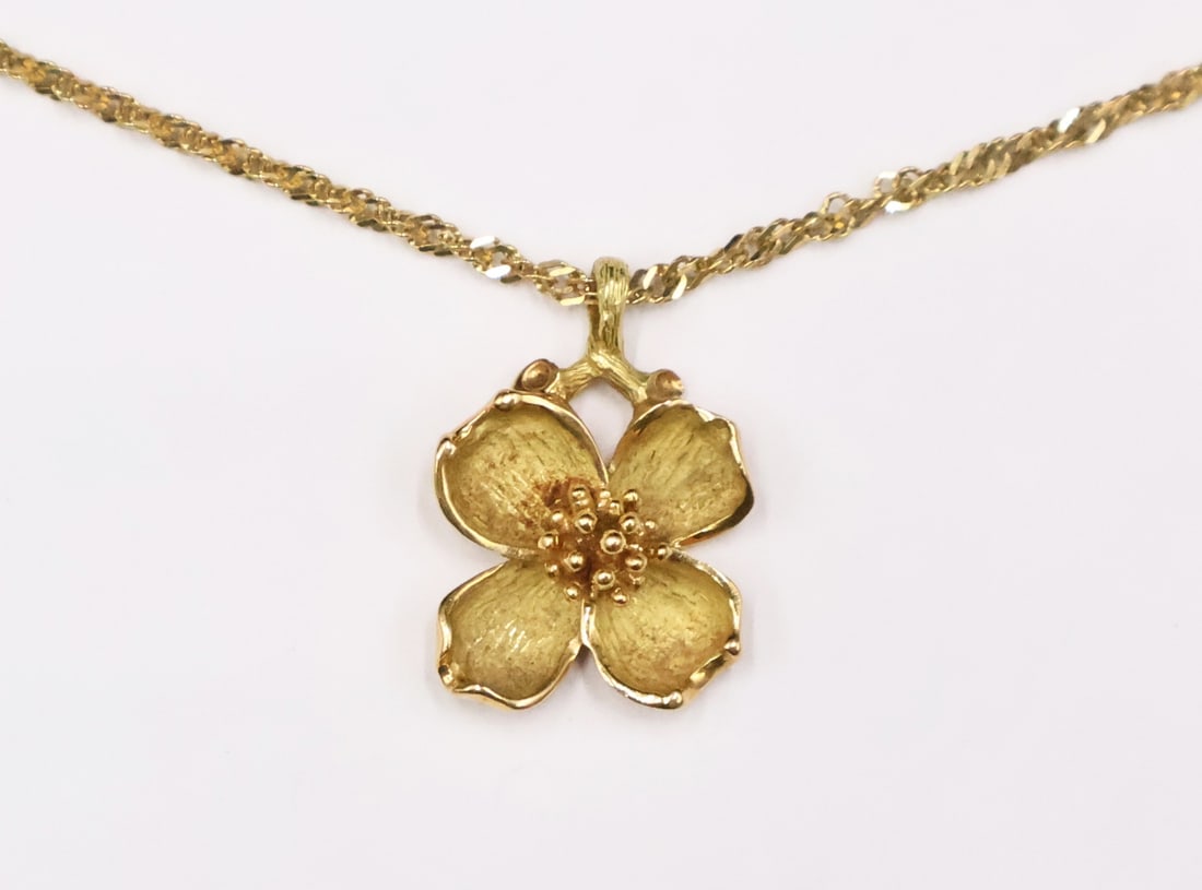 JEWELRY. Tiffany & Co. Dogwood 18kt Gold Pendant.: A signed Tiffany & Co. 18kt yellow gold Dogwood pendant. Stamped, 'Tiffany & Co. 750". Accompanied by a 1.50 mm 14kt yellow gold chain fitted with a lobster claw clasp - stamped, "14