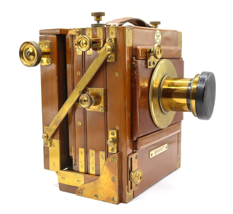 Welling Belgaum S.M.C Cameraworks Camera: A Welling Belgaum S.M.C Wooden Plate Camera is a vintage large-format field camera, crafted from polished hardwood with brass fittings. It features an adjustable bellows. Fitted with a Perken Son &