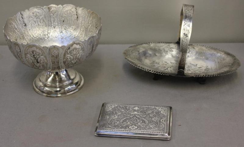Silver Lot.: Includes a beautifully engraved Persian cigarette - hallmarked with gilded interior, a probably silver handled basket with Arabic hallmarks, and a possibly silver Middle Eastern/Indian pedestal bowl w