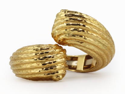 JEWELRY. Italian 18kt Gold Hinged Bypass Bracelet.: Italian 18kt yellow gold handhammered bypass style bracelet with scroll form terminals. In the style of Ilias Lalaounis. Stamped, "750" within a lozenge form frame; an Italian national mark