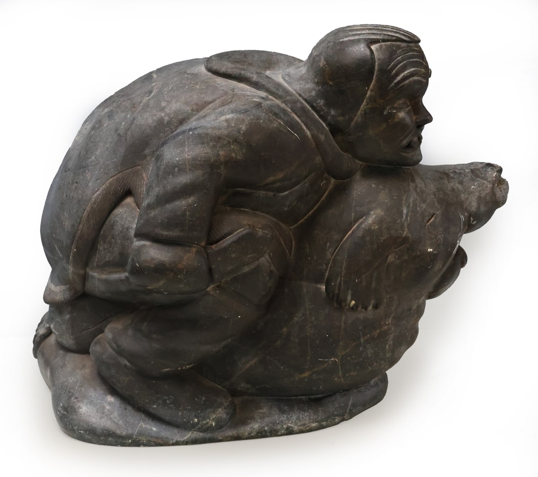 JIMMY ARNAMISSAK (INUIT, 1946-2003).: A carved stone sculpture of a man hunting a seal. Signed, "Jimmy E9-1395". From a Yonkers, NY estate. Dimensions: measures approx. 11.4" h x 15.4" w.