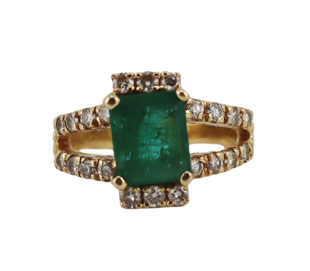 JEWELRY. 14kt Gold, Emerald, and Diamond Ring.: 14kt yellow gold ring displaying a central high prong-set emerald faceted emerald flanked by band of pave diamond accents and set within a pave diamond accented split shank. Emerald measures approx. 7