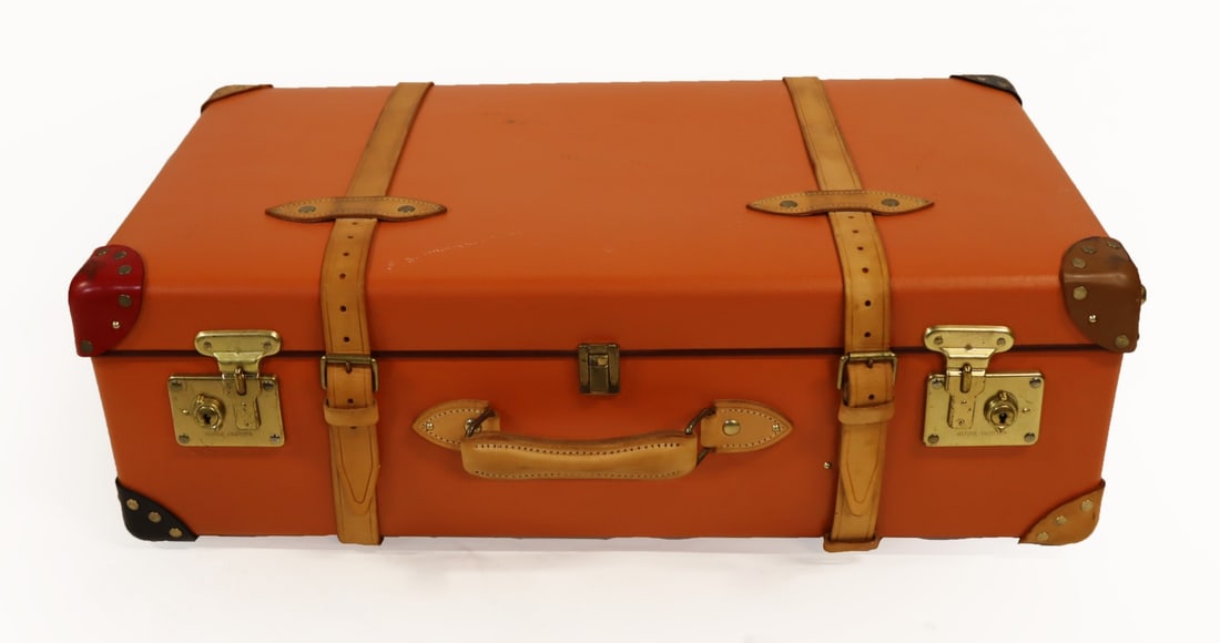 English Globe Trotter Orange Trolley Suitcase.: An English Globe Trotter orange leather two-wheel trolley suitcase with great multi-color floral interior and leather strapping. Inscribed, "Globe Trotter" to hardware. From a Bloomfield, NJ