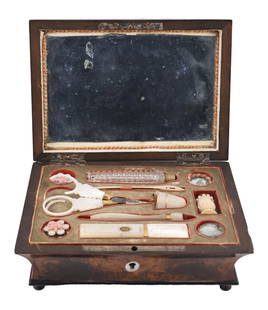 19th Century French Palais Royal French Necessaire: A footed burl wood box displaying an inlaid mother of pearl key hole and accent to the lid with a series of nailed metal pins. The interior includes a sewn cover; (2) mother of pearl thread winders; (