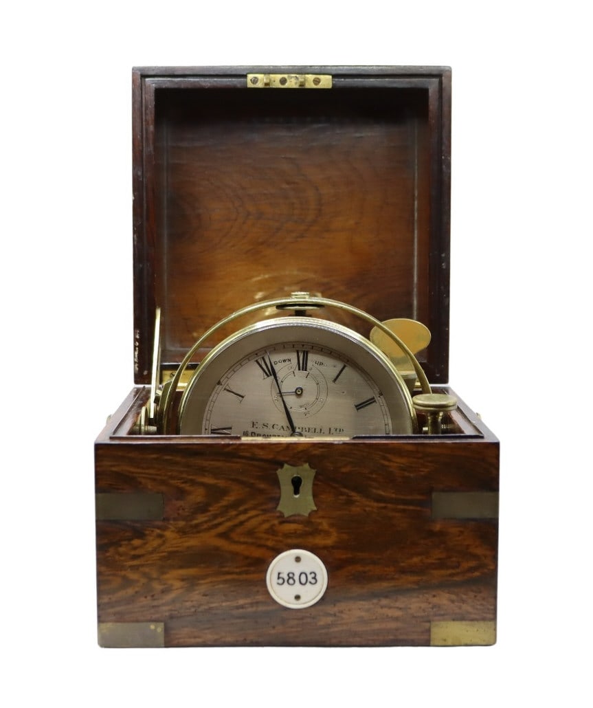 English E.S. Campbell Ltd. Marine Chronometer: An English E.S. Campbell Ltd. marine chronometer housed within its original gimbaled wooden box with brass accents. The chronometer features a silvered metal dial with Roman numeral hour chapter, subs