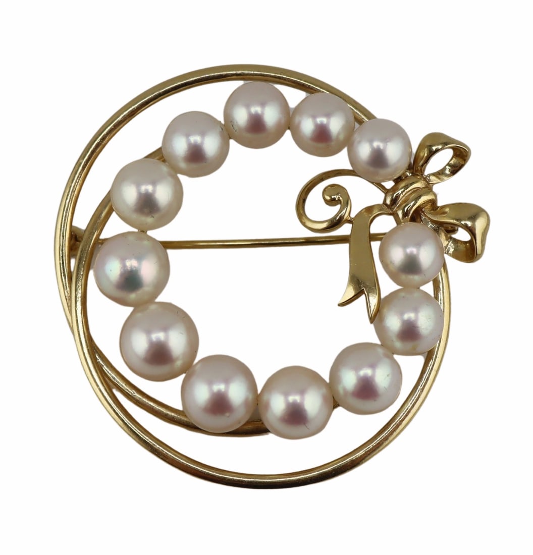 JEWELRY. Mikimoto 14kt Gold & Pearl Wreath Brooch.: Signed Mikimoto 14kt yellow gold wreath form brooch accented by a band of slightly tapered pearls and an applied gold bow. Largest pearl measures approx. 7.2mm; smallest pearl measures approx. 5.6mm.