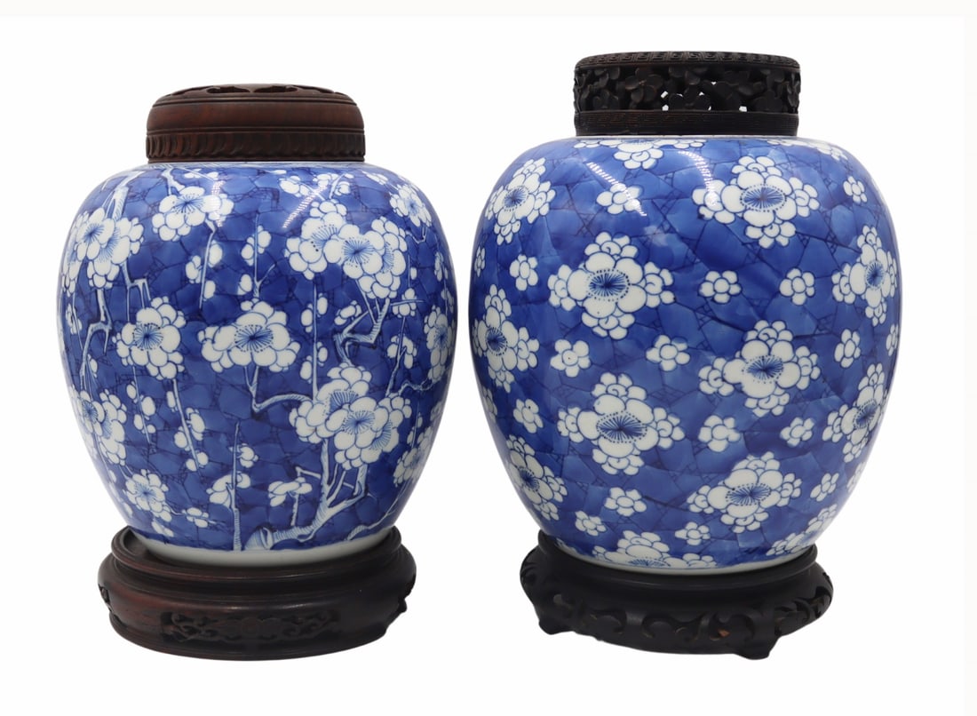 (2) Chinese Blue and White Floral Jars.: Each jar displays a blue double ring mark to the underside. With carved wood lids and bases. Accompanied by a 2/18/81 William Doyle Galleries, Inc. receipt. From a Flushing, NY estate.