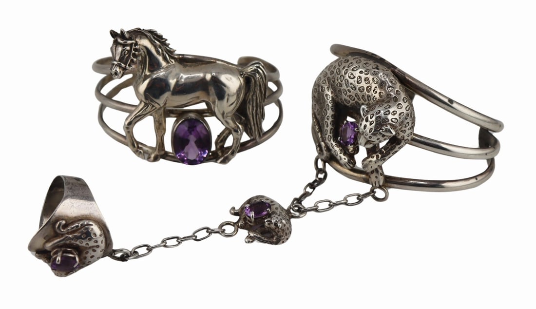 JEWELRY. (2) Carol Felley Sterling Bracelets.: Includes a signed Carol Felley sterling leopard "hand chain" cuff bracelet attached by a chain with leopard and amethyst pendant terminating in a ring with applied leopard and prong-set oval