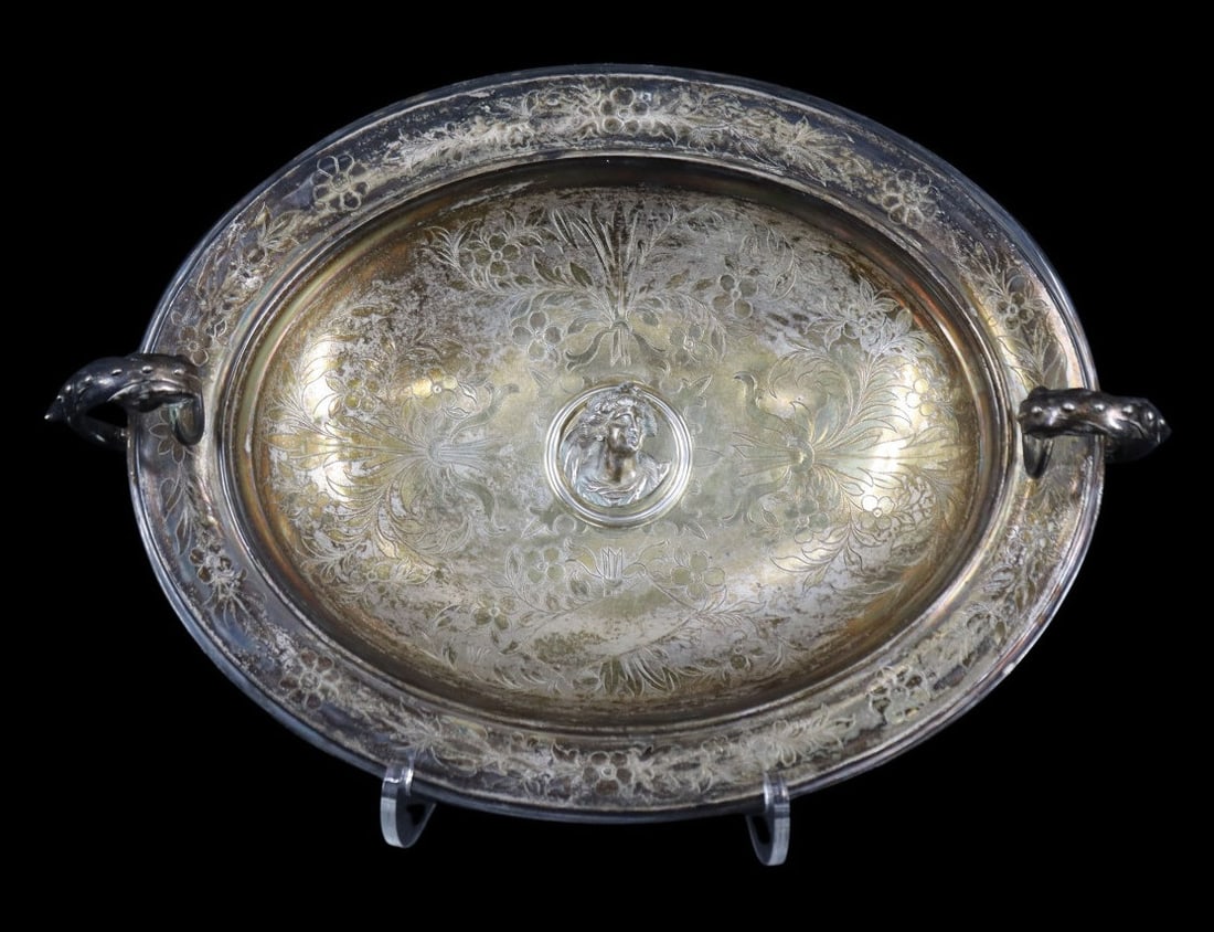 SILVER. Antique Austrian .800 Silver Bowl.: An elegant Austrian silver footed oblong bowl featuring cast dolphin-form handles, each grasping ring knocker in their mouth. The bowl is elaborately decorated with chased floral motifs centering a re