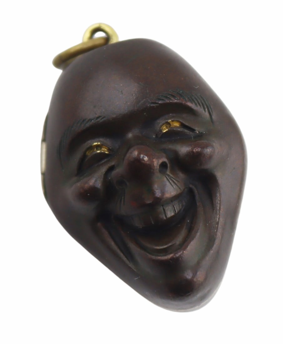 JEWELRY. Signed Japanese Mixed Metal Hinged Locket: Signed Japanese mixed metal hinged locket pendant in the form a a laughing/smiling face. Interior displays a character set with a square frame with rounded shoulders. Total approx. weight of the locke