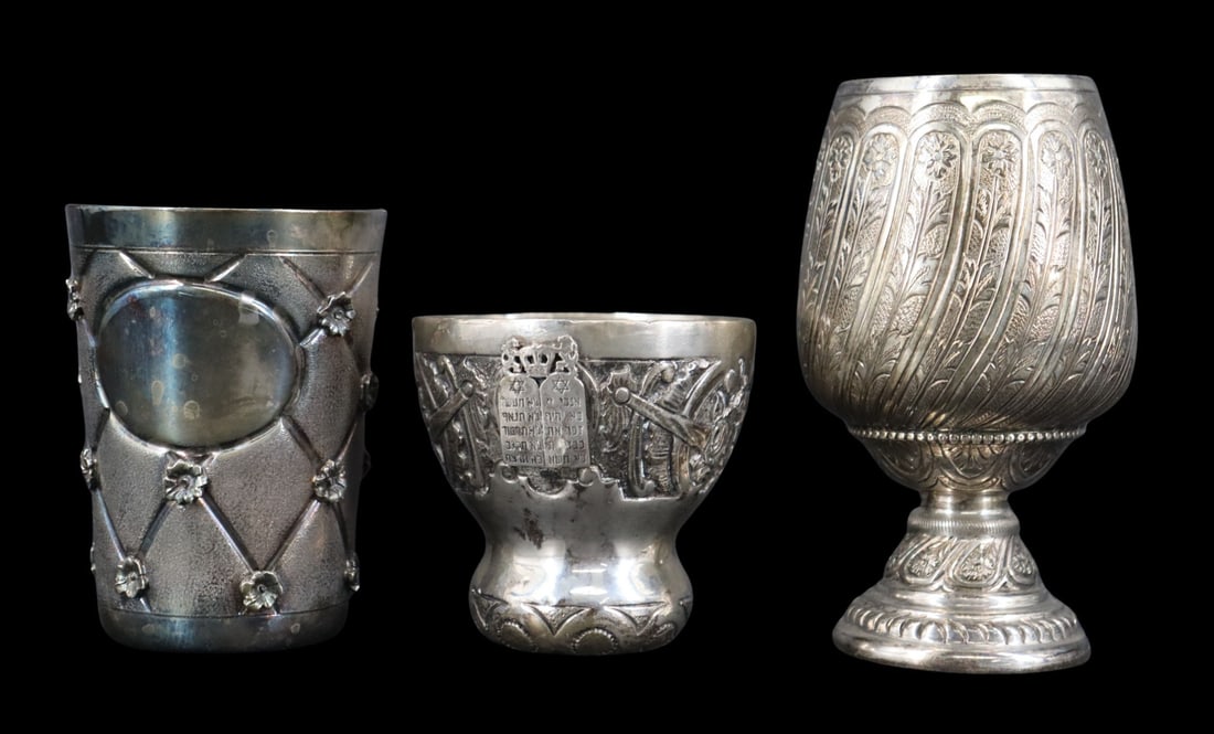 JUDAICA. (3) Assorted Sterling & Silver Kiddush: Cups. Including an unmarked, well-executed Kiddush cup with a frieze decoration and applied tablets under a crown flanked by lions and a Star of David under a menorah; a well-executed sterling footed