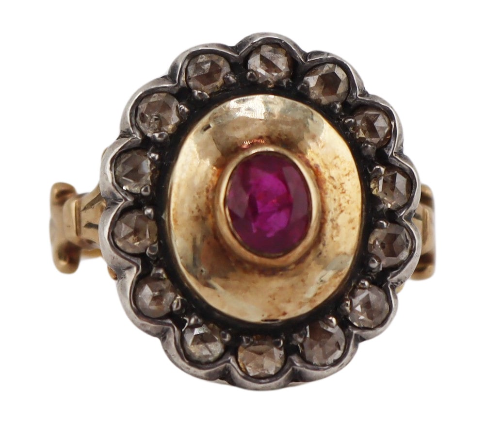 JEWELRY. Silver-Topped Gold, Ruby and Diamond: Ring. 17kt yellow gold cocktail ring displaying a central bezel set oval faceted ruby with polished surround and silver-topped gold scalloped edge border accented by (14) rose cut diamonds. Ruby measu