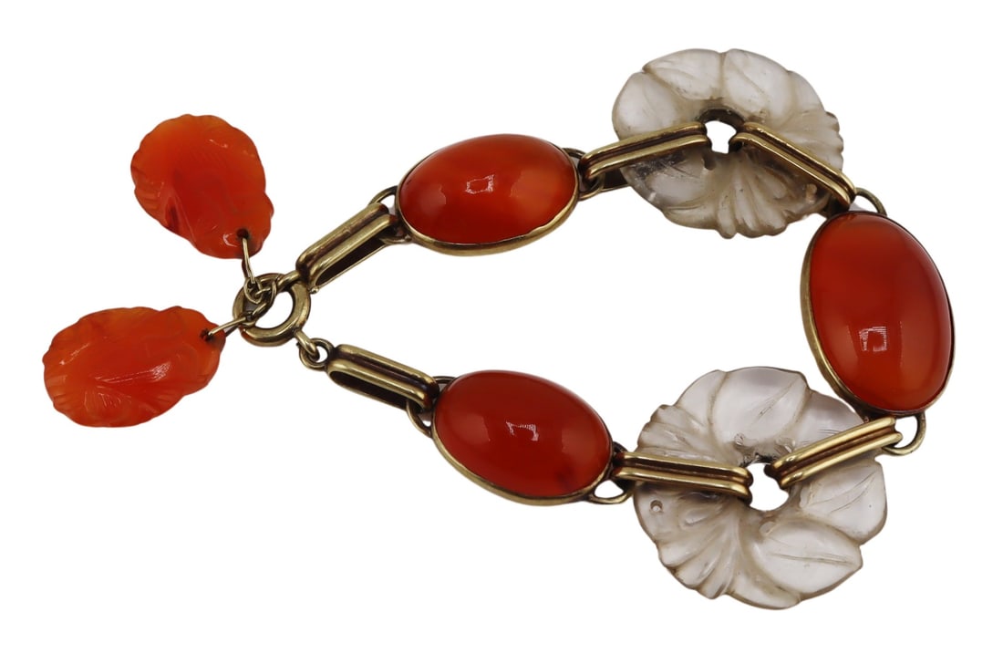 JEWELRY. Art Deco 14kt Gold, Rock Crystal and: Carnelian Bracelet. Art Deco 14kt yellow gold bracelet displaying (2) circular carved rock crystal pendants, (3) bezel set oval Carnelian cabochons, and is accented by (2) possibly later added Chinese