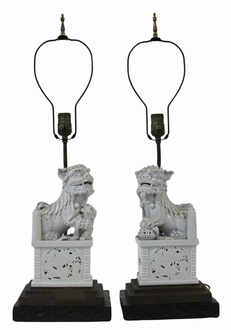 Pair of Chinese Blanc de Chine Foo Dogs as Lamps.: Pair of Chinese blanc de Chine foo dogs set atop pierced bases displaying ruyi pendants, flora, and dragons. Accompanied by a 1984 Tepper Galleries, Inc. receipt. From a Flushing, Queens estate.