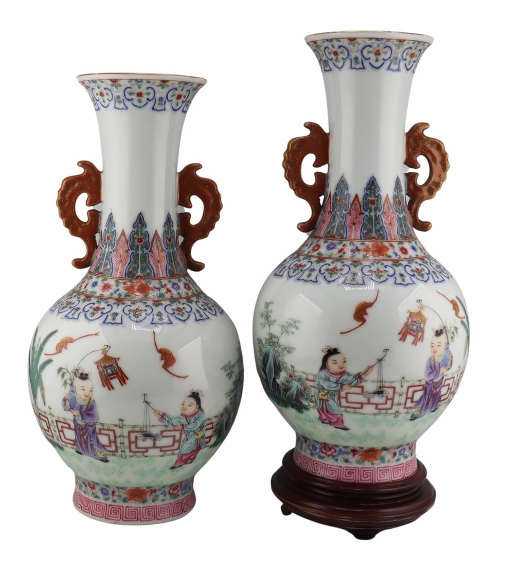 Pair of Chinese Republic Period Enamel Decorated: Vases. Displaying scenes of children playing. With iron red and gilt decorated handles. Marked to the underside. Accompanied by a 1st March 1975 Hong Kong Art Craft Merchants Association Certificate o