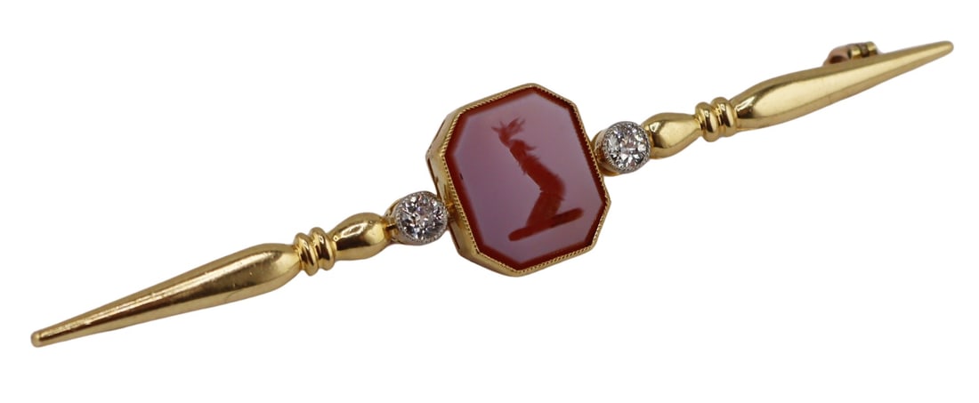 JEWELRY. Antique 16.5kt Gold Carnelian Intaglio: and Diamond Bar Pin. Antique 16.5kt yellow gold bar pin displaying a central Carnelian intaglio of a of a gauntlet or a cubit arm erect holding a dragon's head; flanked by (2) Old European cut diamond