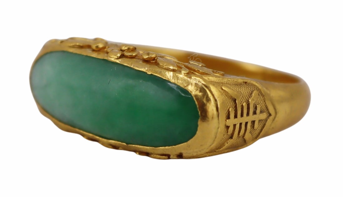 JEWELRY. Chinese High Karat Gold and Jade Ring.: Chinese high karat gold and polished jade saddle ring with lotus flower decoration and Chinese characters to the surround. Gold purity mark of 99.0% with a second 2-character mark. Total approx. weigh