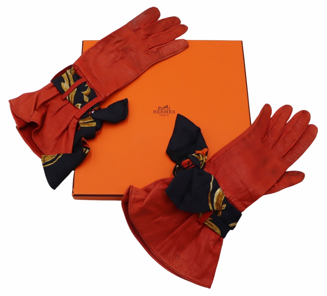COUTURE. Pair of Hermes Orange Leather Gloves.: Pair of Hermes orange leather gloves with multi-color blue ground silk scarf ties. Interior mark of, "Hermes Paris Made in France". Size: 6 1/2. From a New Rochelle, NY estate.