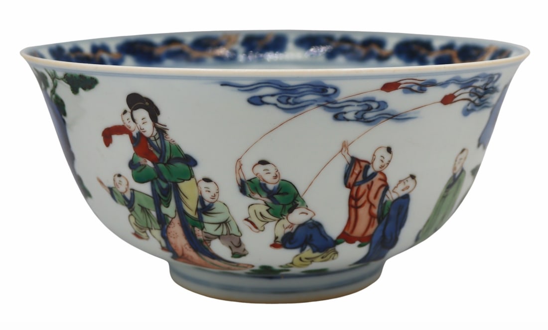 Chinese Wucai Enamel Decorated Bowl.: Exterior of the bowl displays robed figures and children playing in a garden; interior of the bowl displays three children playing and a border of pine tree branches. Six character mark set within a d