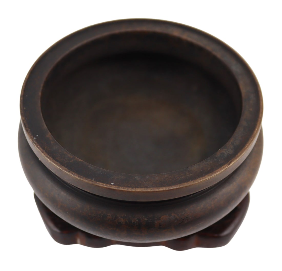 Signed Chinese Bronze Tripod Censer.: With a six character mark to the underside. On a fitted carved wood base. From a Cliffside Park, NJ estate. Dimensions: censer measures approx. 4" in diameter x 2" h.