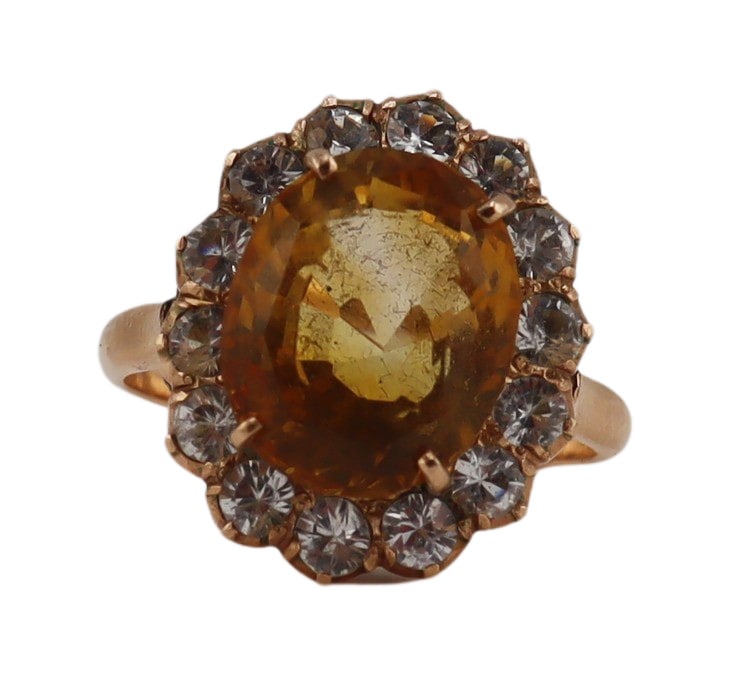 JEWELRY. Gold and Colored Gem Cocktail Ring.: An unmarked 10kt yellow gold ring set with a central prong-set yellow faceted gemstone within a halo of individual prong-set round-cut white topaz. From a Greenwich, CT estate. Dimensions: ring face m