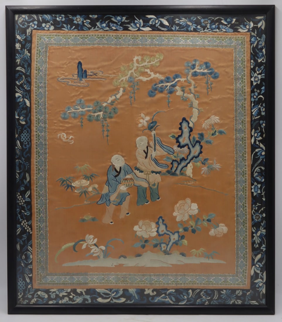 Chinese Embroidered Silk Panel of Figures.: Chinese silk embroidered panel displaying two standing figures conversing amongst trees and foliate set against a peach colored silk ground; with a silk embroidered border in blues and white. From a N