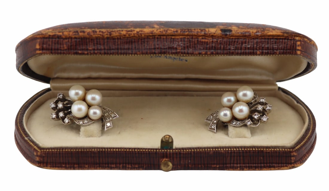 JEWELRY. 12.5 & 14kt Gold, Pearl and Diamond: Earrings. Pair of 12.5kt white gold ribbon spray earrings with 14kt white gold backings - displaying (4) round pearls of various sizes, pave diamond inlaid ribbons, and prong-set single cut diamonds