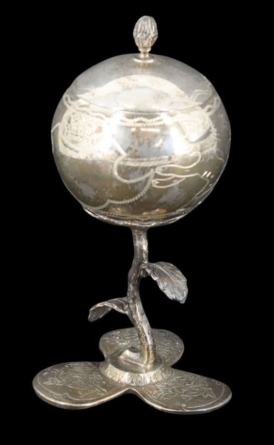 JUDAICA. Silver Besamim Spice Box: An unmarked silver three-piece Besamim spice box comprising the lid, stem, and base. The body is a spherical vessel surmounted by a finial, chased with a pair of confronting lions flanking a blank