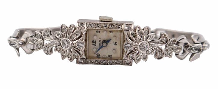 JEWELRY. Platinum and Diamond Cocktail Watch.: A platinum and diamond accented concealed cocktail watch fitted with a metal bracelet with faux diamonds. This watch features a 14.25 mm diamond-accented rectangular watch case, acrylic crystal,
