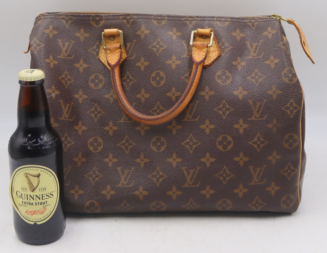 COUTURE. Louis Vuitton Monogrammed Leather Bag.: Louis Vuitton monogrammed leather Speedy bag. Serial no. to the interior. From an East Patchogue, NY estate. Dimensions: 14" w x 7.5" d x 9.5" h.