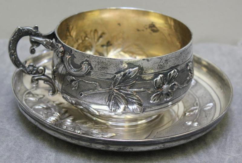STERLING. Alphonse Debain Floral Cup and Saucer.: Beautiful repousse floral and leaf design to both the cup and saucer. With hallmarks of Alphonse Debain, French, circa 1883-1911. These 2 pieces are .950 silver. Approx. 14.3 troy oz. From a Harrison,