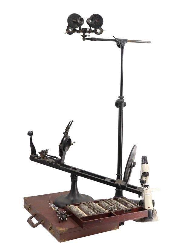 Ophthalmology and Optometry Equipment.: To include an antique phoropter mounted on a tall stand, an antique trial lens case containing various lenses for testing vision manufactured by the American Optical Company, a universal trial frame; 