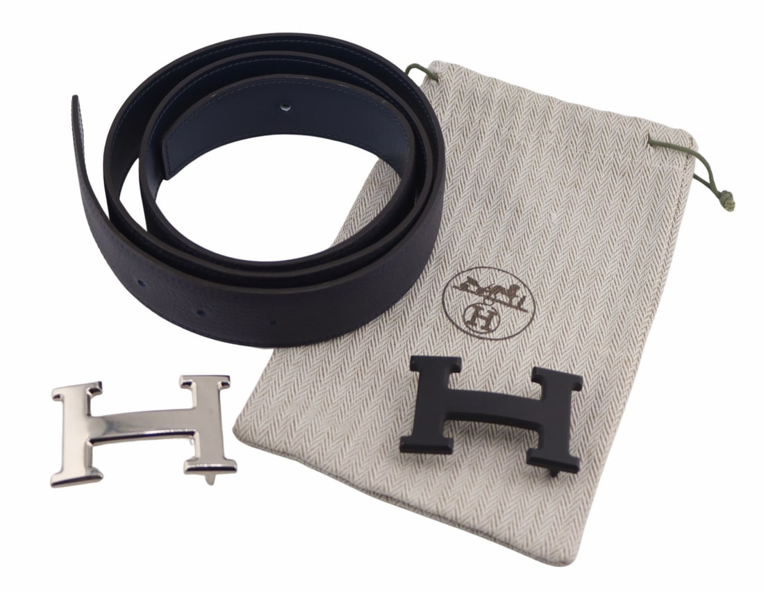 COUTURE. Hermes Reversible Leather Belt with (2): H Buckles. Includes an Hermes reversible navy blue leather belt - stamped, "90 7 ID 440 CF Hermes Paris Made in France"; a matte black "H" buckle - stamped, "Hermes" to t