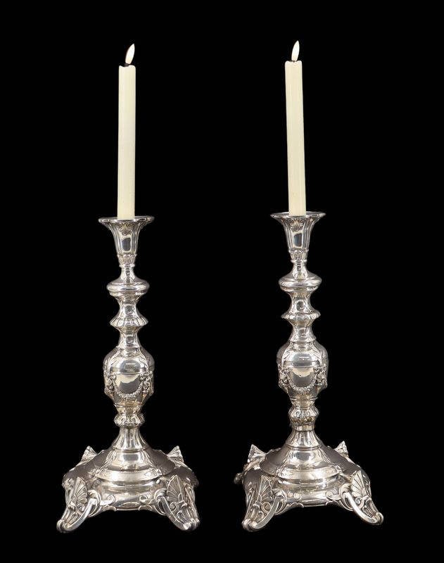 JUDAICA. German .800 Silver Shabbat Candlesticks: A pair of German .800 silver Shabbat candlesticks. Each candlestick features a tall, tapering standard with richly cast and chased decoration, including lobed baluster elements and scrolling foliate m
