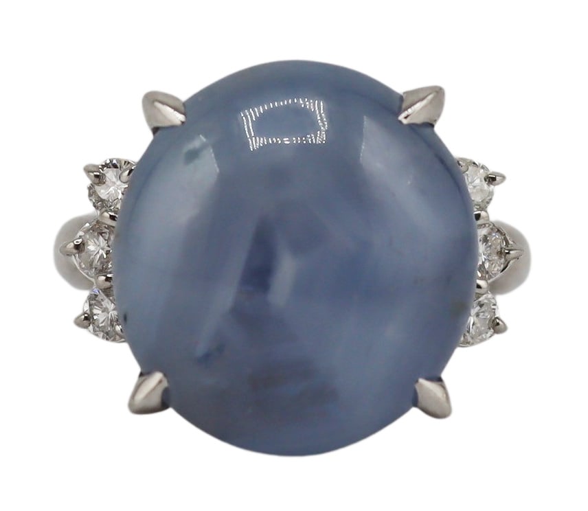 JEWELRY. GIA Unheated Ceylon STAR Sapphire and: Diamond Ring. Platinum cocktail ring displaying a central prong-set oval 34.77ct Ceylon star sapphire flanked by (6) round brilliant cut diamonds. Accompanied by a March 12th, 2020 Sapphire Origin Rep