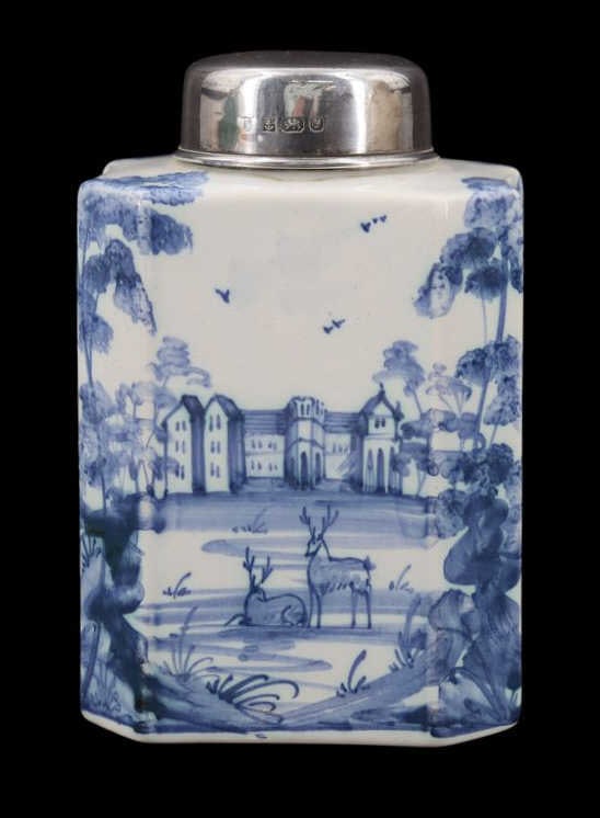 SILVER. English Silver Mounted Delftware Tea Caddy: A modern English silver mounted English delftware porcelain tea caddy executed by Deborah Sears of Isis Ceramics, of traditional form and finely decorated with a continuous pastoral landscape featurin