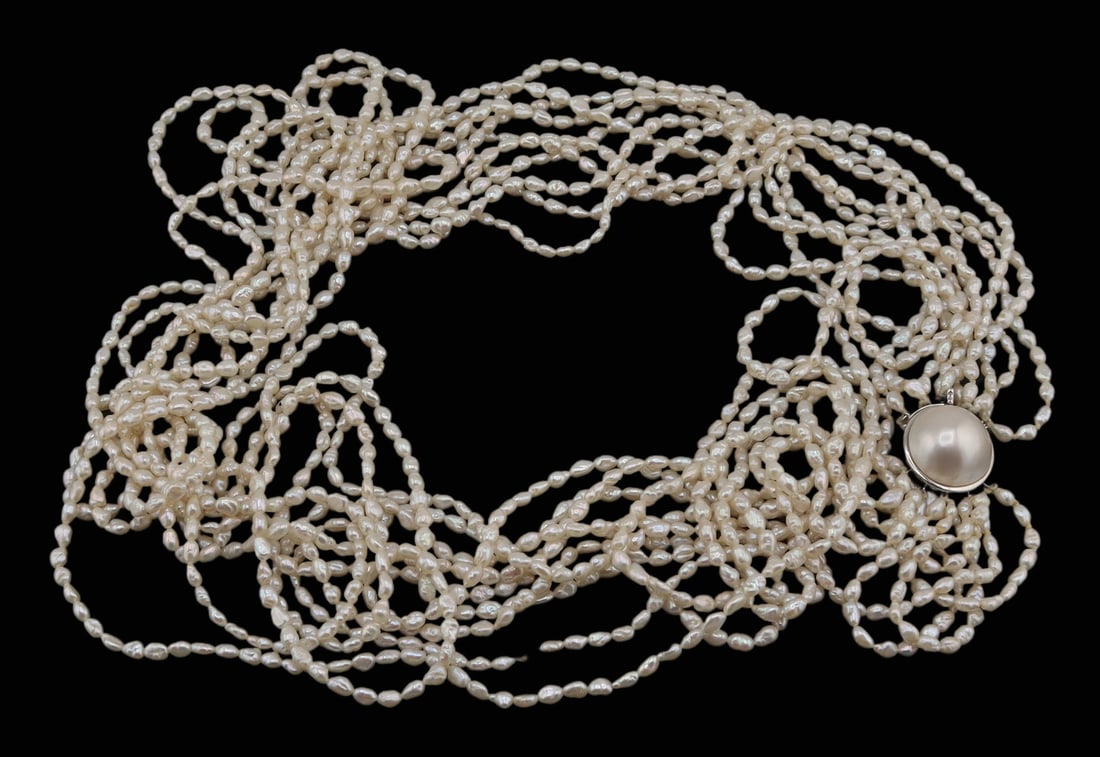 JEWELRY. DAVID WEBB 18kt Gold and Keshi Pearl: Necklace. David Webb multi-strand keshi pearl necklace with an 18kt white gold circular clasp displaying a mabe pearl. Total of (10) single strands with one detached but present. Clasp is stamped, &qu