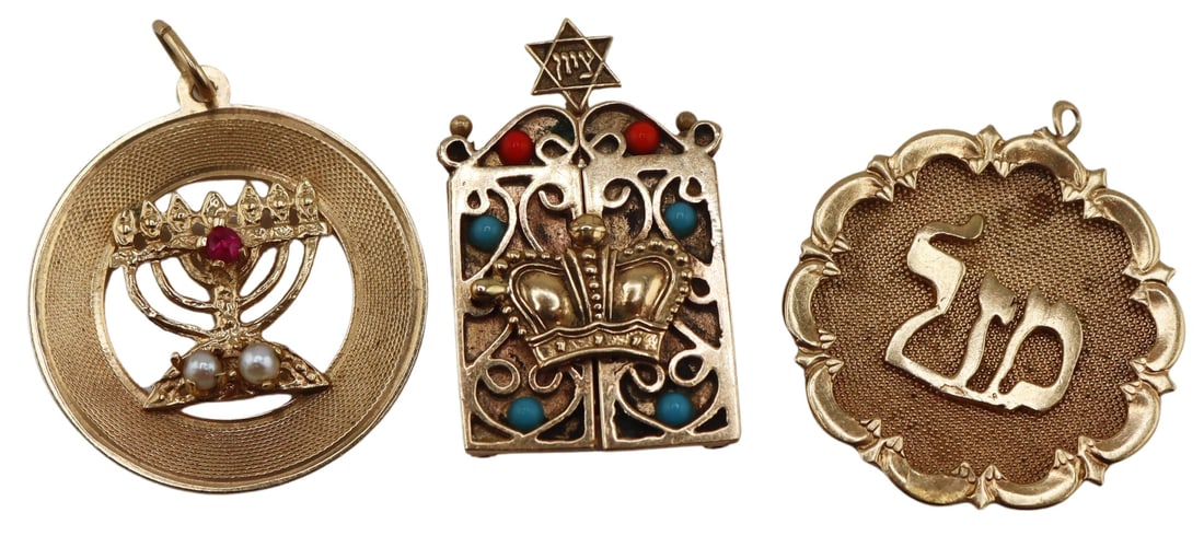 JUDAICA. (3) Assorted Gold Pendants.: Includes a 13.5kt yellow gold circular pendant displaying an applied menorah accented by a single round faceted ruby and two pearls - stamped, "14K" verso; a 14kt gold hinged Judaic pendant 