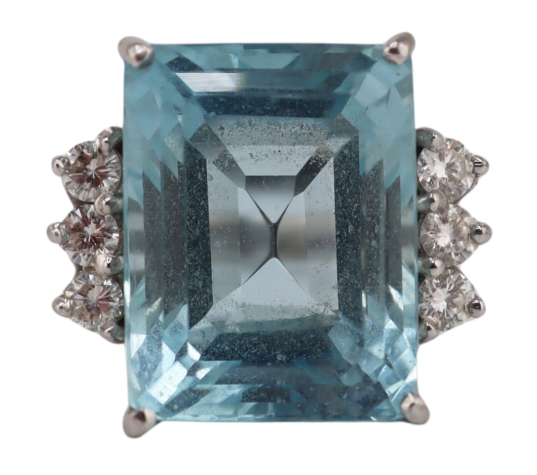 JEWELRY. 18kt Gold, Gem and Diamond Ring.: 18kt white gold cocktail ring displaying a central prong-set emerald faceted blue gem, presumably an Aquamarine, flanked by trios of round full cut diamond accents. Gem measures approx. 12.5mm x 16.5m