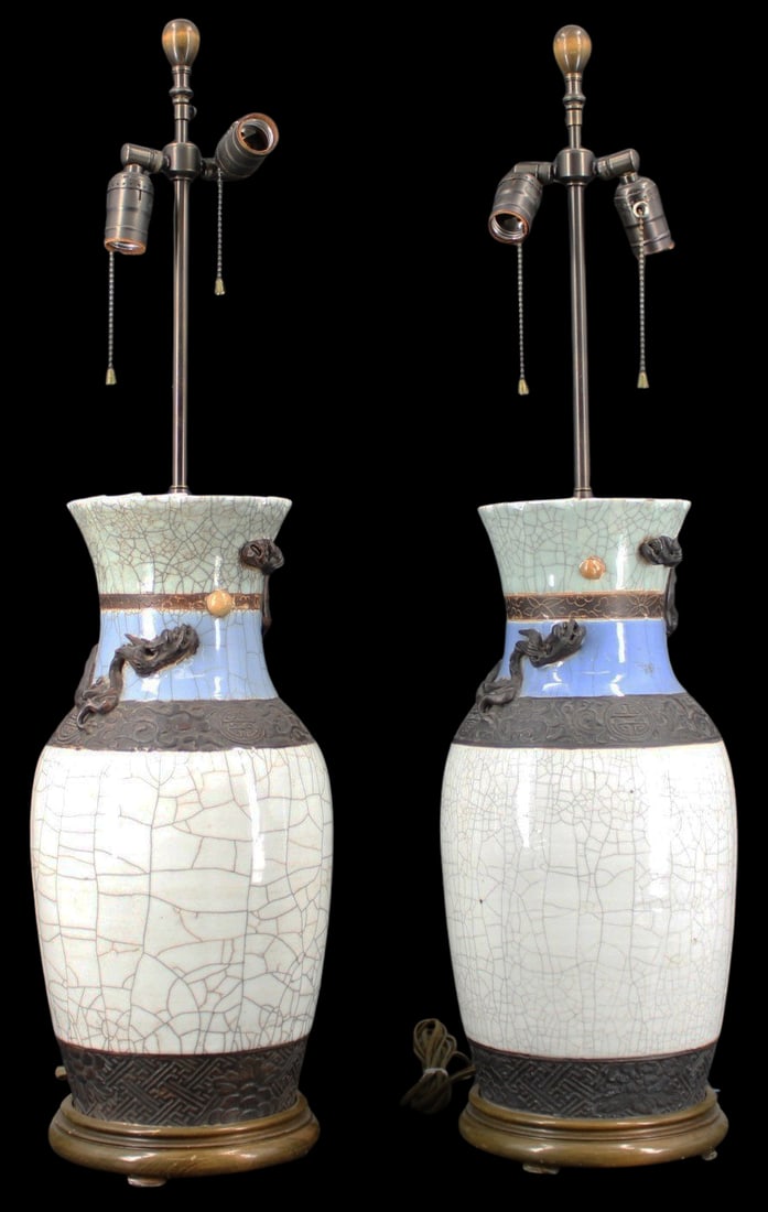 Near Pair of Chinese Crackle Glaze Ceramic Lamps.: Near Pair of white Chinese crackle glaze vase mounted lamps decorated with metal work depicting flowers, longevity symbols, geometric patterns & dragons in flight on each. A carved 4-character mark on