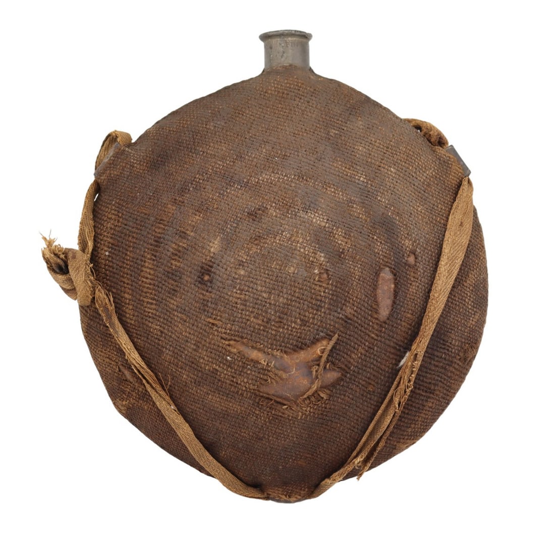 MILITARIA. U.S. Model 1858 Civil War Bullseye: Canteen. American Civil War period "Bullseye" canteen manufactured by A. Hadden, Porter & Booth of Philadelphia. This canteen features the distinctive concentric ring ("bullseye") pressed body and ret
