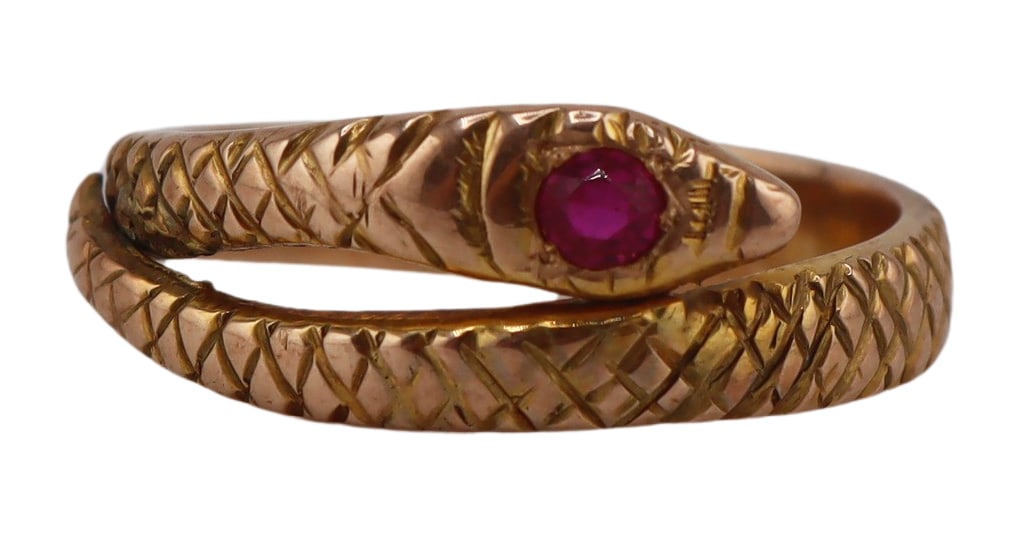 JEWELRY. Signed 14kt Gold and Ruby Snake Ring.: Signed M 14kt yellow gold coiled snake form ring accented by a flush set round faceted ruby to the head. Ruby measures approx. 2.5mm. Stamped to the interior of the band, "14K M". Total approx. weight
