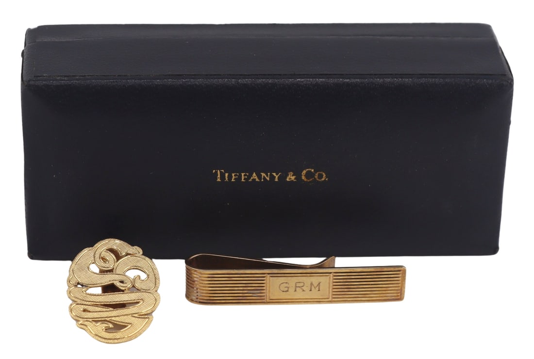 JEWELRY. Cased Tiffany & Co. 14kt Tie Slide: A cased Tiffany & Co. 14kt yellow gold tie slide - stamped, "14K Tiffany & Co". Accompanied by a 14kt yellow gold Monogram tie clip - stamped, "14K". Total approx. weight of both items is 6 dwt (gross