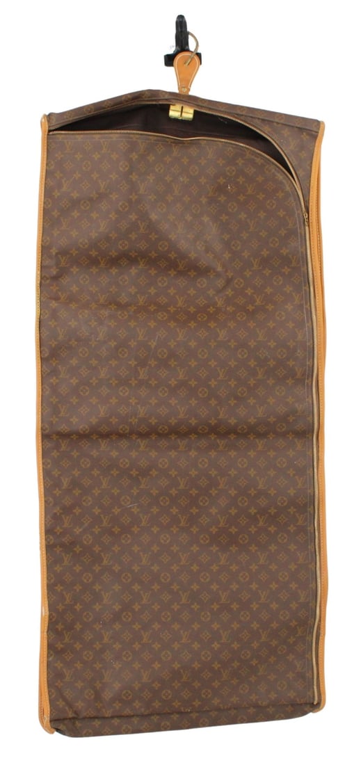 COUTURE. Louis Vuitton Hanging Garment Bag.: Hanging Louis Vuitton monogrammed garment bag with gold-tone hardware. Two pockets on the front, one large verso. From a Larchmont, NY estate. Dimensions: approx. 50.375" h x 23" w x 3" d.